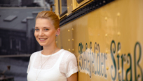 Charlotte Kleineberg vor einer alten Bielefelder Straßenbahn.