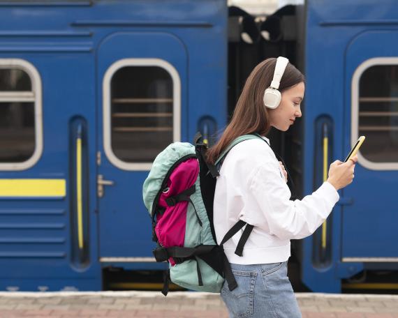 Frau mit Rucksack am Bahnhof